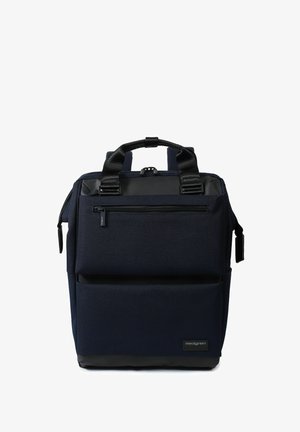 Sac à dos carré bleu foncé avec deux grandes poches zippées, poignées noires et une petite étiquette de marque en bas à droite.