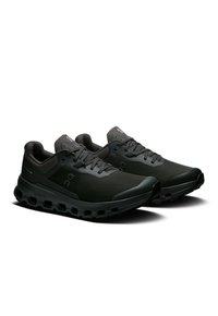 Schwarze Sportschuhe mit strukturiertem Obermaterial, flachen Schnürsenkeln und einer dicken, gepolsterten Sohle mit Ausschnitten zur Stoßdämpfung.