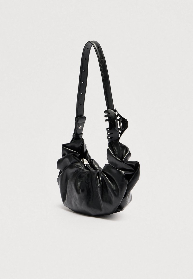 Black leather handbag with scrunched body, wide adjustable strap, and a black plastic clip on strap.