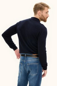 Navyblauer Strickpullover mit Kragen, getragen über blauen Denim-Jeans. Der Pullover hat lange Ärmel und ein tailliertes Design.