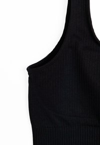 Svart ribbad bralette med rundad halsringning och breda axelband. Texturen är slät med vertikala ribbor. Fokuserar på enkelhet i designen.