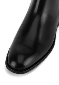 Must musta ankle boot, mille viimistluse, terava nina ja peene õmbluse detailiga tald. Ühtlane sile tekstuur.