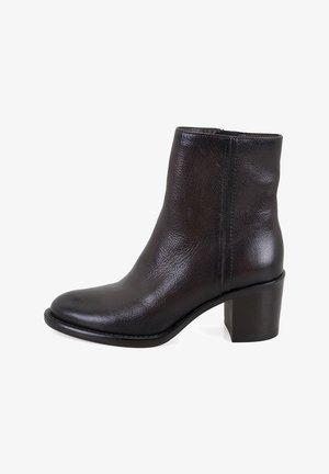 Bottines noires en cuir avec un bout arrondi et un talon bloc moyen. Présente une texture lisse et un design minimaliste avec des coutures sur les côtés.