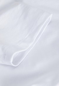 Vit bomull T-shirt tyg, vikt och visar slät textur, liten lyster och rena sömmar. Inga mönster eller dekorationer.