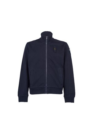 Veste zippée bleu marine en tissu doux, avec un col montant, des poches latérales et une étiquette sur la poitrine avec de petites accents en métal.