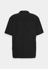 Chemise noire à manches courtes avec une coupe décontractée, une texture lisse et un col classique ; dos uni sans détails ou motifs supplémentaires.