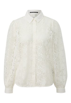 Blusa bianca di pizzo con colletto, chiusura a bottoni frontale e maniche lunghe a sbuffo. Presenta motivi circolari e tessuto strutturato.