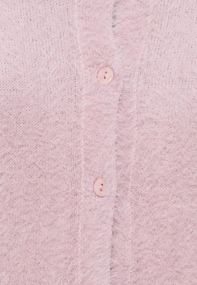 Mäkký, svetloružový kardigán vyrobený z nadýchaného pleteného vlákna s predným zapínaním na gombíky, ktorý je ozdobený guľatými pastelovými ružovými gombíkmi a textúrovaným povrchom.