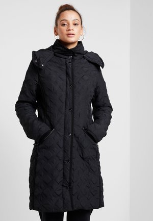Cappotto isolato nero con una texture trapuntata, colletto alto e chiusura a bottoni. Include tasche laterali e un cappuccio rimovibile.