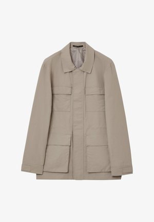 Veste beige, légère, à manches longues avec col, dotée de deux poches poitrine et de deux poches à rabat inférieures. Tissu texturé.
