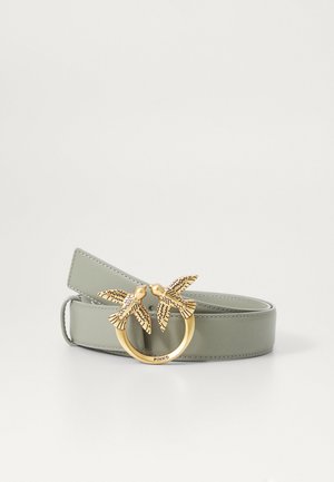 Grønt lærbelte med en gullsirkelspenne med to fugleformede detaljer, utført med inngravert mønster. Slank tekstur, elegant design.