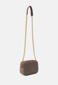 Klein rechthoekig bruine quilted crossbody tas met gouden kettingriem en bovenste ritsluiting op een witte achtergrond.