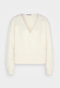 Kermanvärinen, neulottu kietaisuneule, jossa on V-aukko, teksturoitu kuvio, pitkät hihat ja istuva helma. Huomionarvoinen pehmeä materiaali.