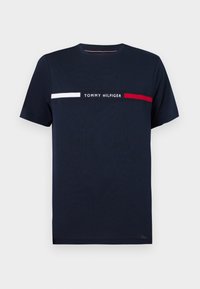 Navy cotton t-paita lyhyillä hihoilla, jossa on valkoisia ja punaisia vaakaraitoja ja "TOMMY HILFIGER" -teksti keskellä. Klassinen pyöreä pääntie.