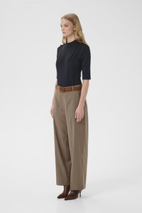 Tumesinine lühikeste varrukatega pluus vertikaalsete õmblusdetailidega, kombineeritud beežide laia säärega pükstega ja pruuni nahkvööst. Välimuse lõpetavad pruunid kontsaga saapad.