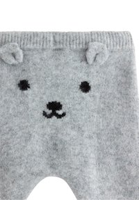 Grå strikkede leggings med et bjørneansigt design; har sorte broderede øjne og næse, samt små bjørneører ved taljen.