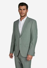 Lichtgrijs pak met een gestructureerd patroon, sluiting met één knoop, notch revers en twee frontzakken. Vergezeld van een witte formal shirt.