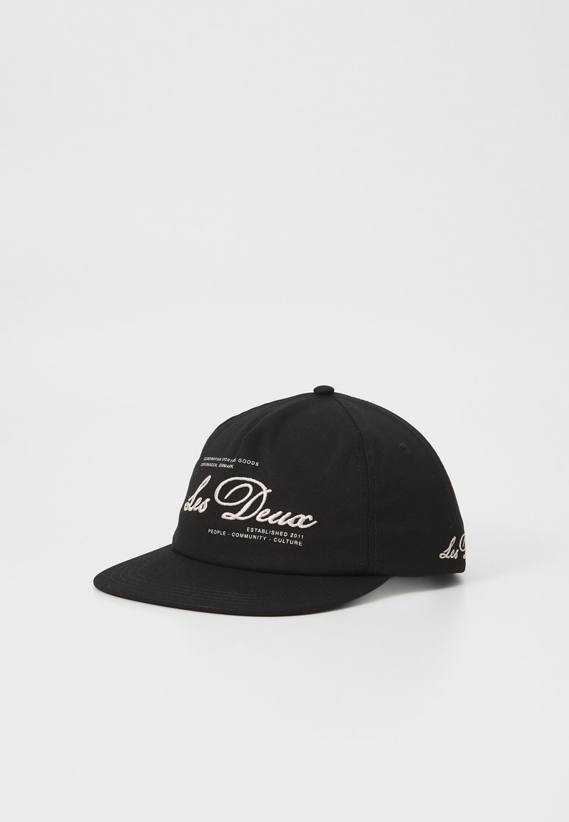 Black baseball cap made of cotton. Features embroidered white text and logo on front, curved bill, and adjustable strap at the back.