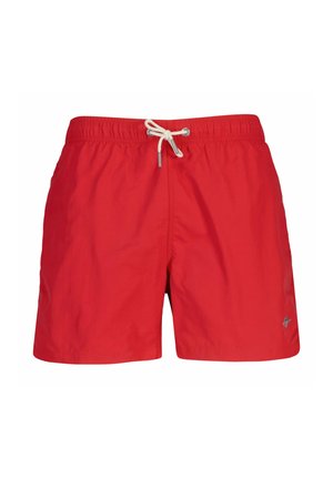 Shorts de bain rouges avec taille élastique et cordon blanc, arborant un petit logo sur la partie inférieure de la jambe droite.