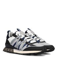 Sneakers met een grijze mesh bovenkant, marineblauwe en zwarte accenten, geweven banden en een dikke rubberen zool met ronde noppen. Witte veters en logo-detail.