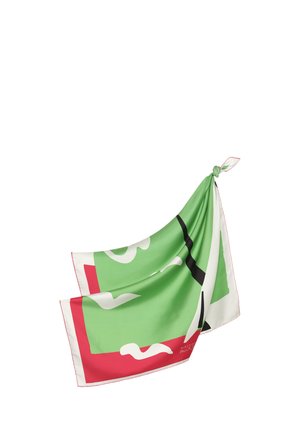 Foulard en soie avec des motifs géométriques verts, blancs, noirs et rouges, noué à un coin sur fond blanc.