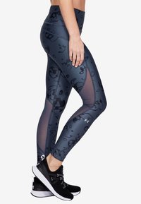 Leggings a vita alta di colore grigio scuro con una sottile stampa animale, dotati di pannelli in rete e tessuto liscio e elasticizzato. Abbinate a scarpe da corsa nere.