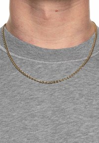 Guld kæde halskæde hviler på en grå crewneck t-shirt, med et sammenkoblet linkdesign og en glat, skinnende overflade.