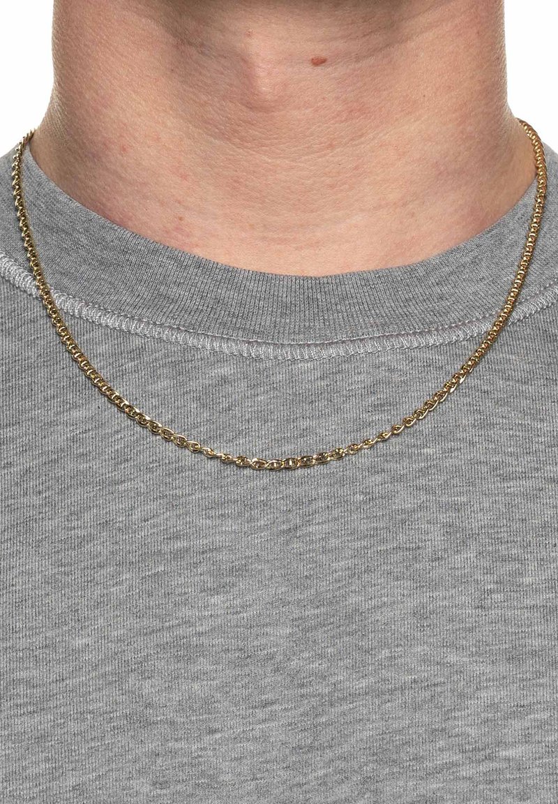 Collana di catena dorata appoggiata su una maglietta grigia a maniche corte, con un design a link interconnessi e una finitura liscia e lucida.