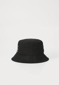 Black bucket hat made from cotton with a rounded crown, wide brim, and embroidered logo detail on the front. Textured fabric.