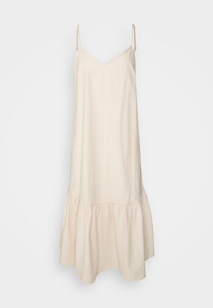 Beige mouwloze maxi-jurk met dunne schouderbandjes en een gerimpelde volantzoom aan de onderkant.