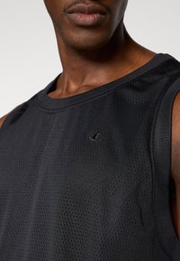 Μαύρο αμάνικο αθλητικό μπλουζάκι από δίχτυ με στρογγυλή λαιμόκοψη και μικρό λογότυπο στο στήθος, κατασκευασμένο από υφή υφάσματος που επιτρέπει την αναπνοή.