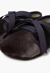 Dunkle Samtballetschuhe mit runder Zehenpartie, ausgestattet mit einem blauen Band zum Binden. Weiche Textur und glatte Oberfläche mit leichtem Glanz.