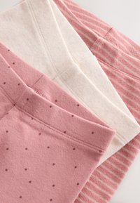 Trois paires de leggings en tissu : une rose unie avec des motifs à pois, une ivoire avec une texture subtile, et une rose à rayures. Matériau doux et extensible.