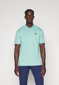Mintgrønn polo-skjorte med to knapper i knappeleppen og korte ermer, med en liten gul sommerfugl-logo på venstre bryst.
