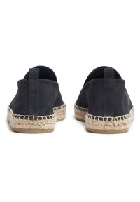 Espadrilles en suède gris foncé avec une semelle en jute et un talon plat, présentant un dos fermé et des coutures le long des bords.