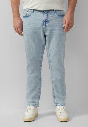 Lichtblauwe denim jeans met een rechte pasvorm, standaard vijf-pocket stijl en subtiele vervaging. Gecombineerd met witte sneakers.