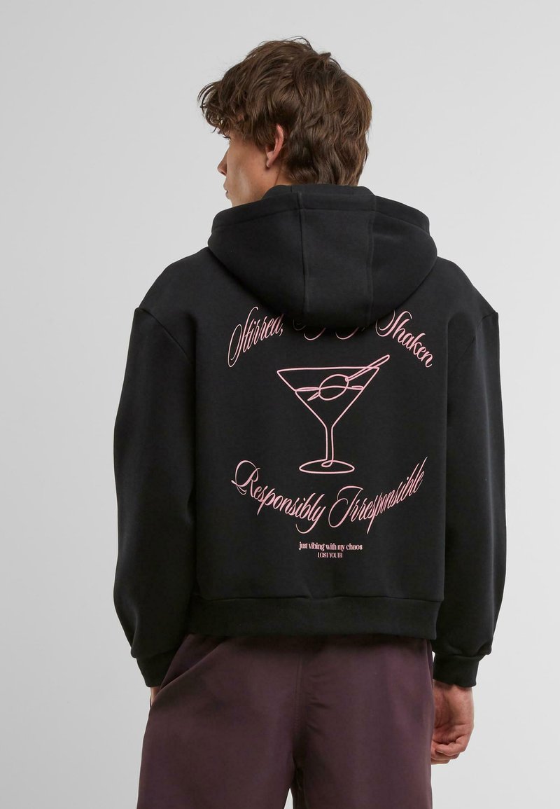 Felpa nera con cappuccio caratterizzata da testo grafico rosa e un design di un bicchiere di martini sul retro. Tessuto morbido, vestibilità rilassata, stile corto.