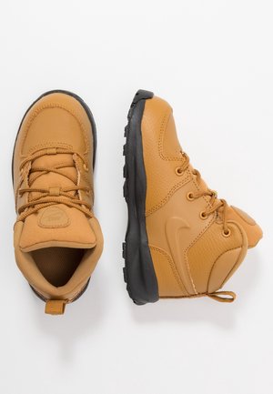 Paire de bottines beige et noires à lacets pour bébé, l'une vue de dessus et l'autre de profil sur fond blanc.