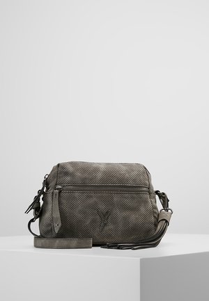 Small gray crossbody bag with perforated texture, front zip pocket, tassel detail, and adjustable strap displayed on white pedestal.