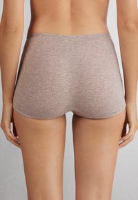 Bruna ribbade underkläder med hög midja och sömlösa kanter. Materialet verkar mjukt med en dämpad textur, lämpligt för vardagsbruk.