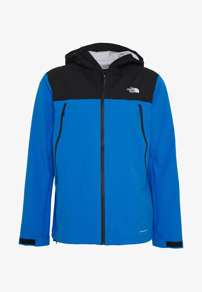 Veste imperméable à capuche bleue et noire avec fermeture éclair sur le devant, deux poches poitrine zippées et logo The North Face sur la poitrine.