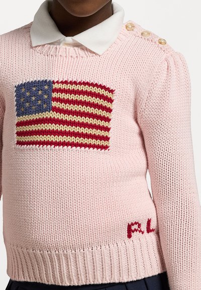Suéter malha rosa claro com um design texturizado da bandeira americana em vermelho, branco e azul, com botões decorativos nos ombros.