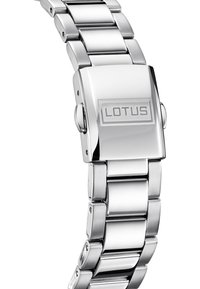 Silverfärgad metallklocka med en rektangulär urtavla och integrerat armband. Har ett spänne med "LOTUS"-logotypen och en polerad yta.