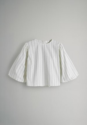 Valge, lühikeste varrukatega top, millel on vertikaalsed mustad triibud, ümmargune kaelus ja laternavarukad. Valmistatud siledast kangast, millel on kerge tekstuur.