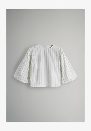 Valge, lühikeste varrukatega top, millel on vertikaalsed mustad triibud, ümmargune kaelus ja laternavarukad. Valmistatud siledast kangast, millel on kerge tekstuur.