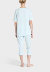 Set di pigiama azzurro chiaro composto da una maglietta a maniche corte e pantaloni capri. Tessuto morbido, vestibilità comoda con dettagli di cucitura delicati.