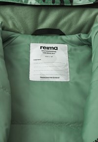 Zielona wodoodporna kurtka od środka z miękką fakturą. Metka z nazwą marki "reima", rozmiar 104/4T, instrukcje pielęgnacji i wiadomość.
