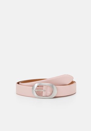 Lichtroze leren riem met een gladde textuur en een grote ovale zilveren metalen gesp, plat opgerold op een witte achtergrond.