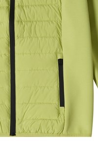 Section de veste matelassée vert clair avec fermeture éclair verticale noire et fermeture éclair de poche latérale sur panneau en tissu lisse.