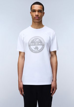 T-shirt bianca in cotone con una grande grafica circolare argentata sul davanti, con testo e un design della mappa dell'Antartide. Maniche corte, colletto girocollo.